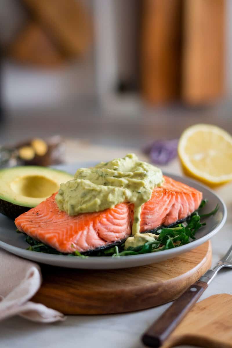 Baked salmon with creamy avocado sauce served on a plate