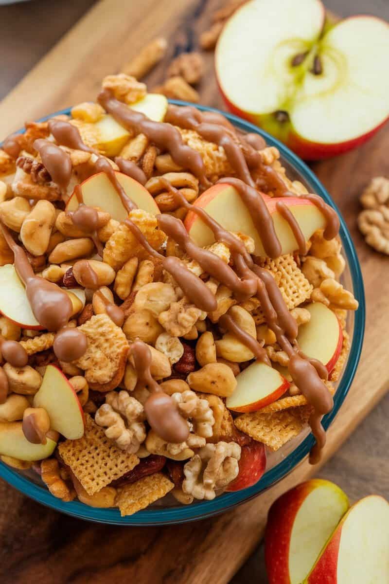 Bowl of Caramel Apple Chex Mix with nuts and apple slices