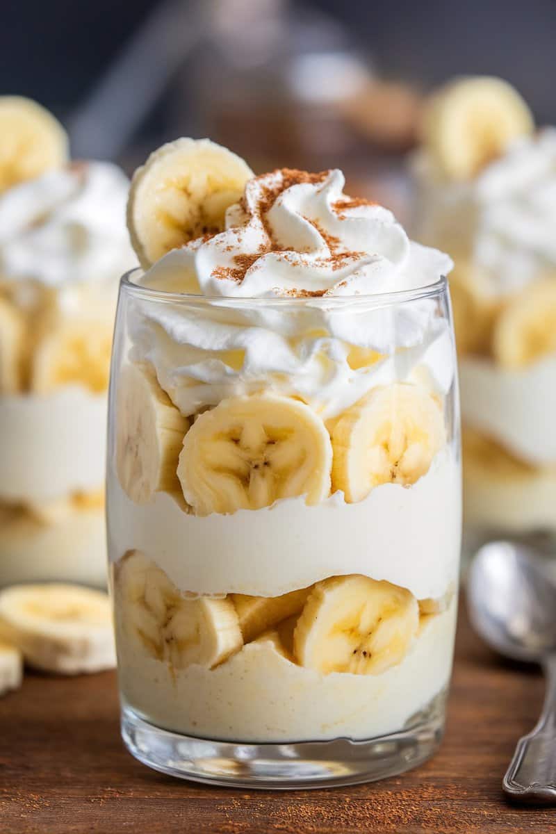 A delicious banana pudding parfait layered with bananas and whipped cream, topped with a sprinkle of cinnamon.