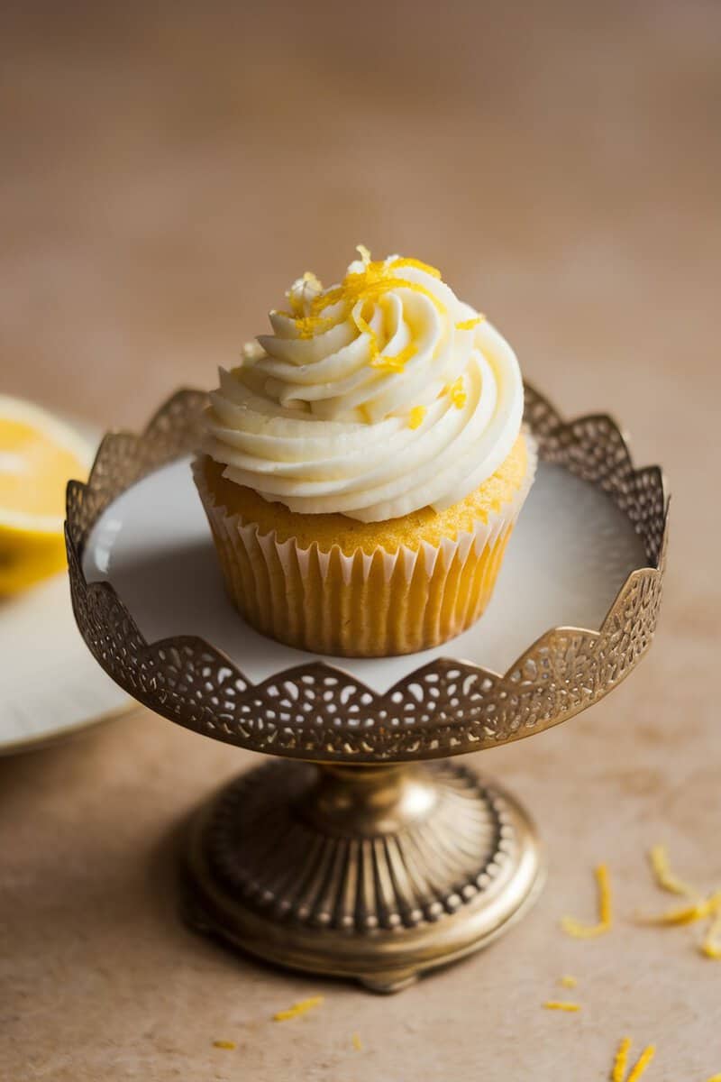 Lemon zest cupcake with cream cheese frosting on a decorative stand