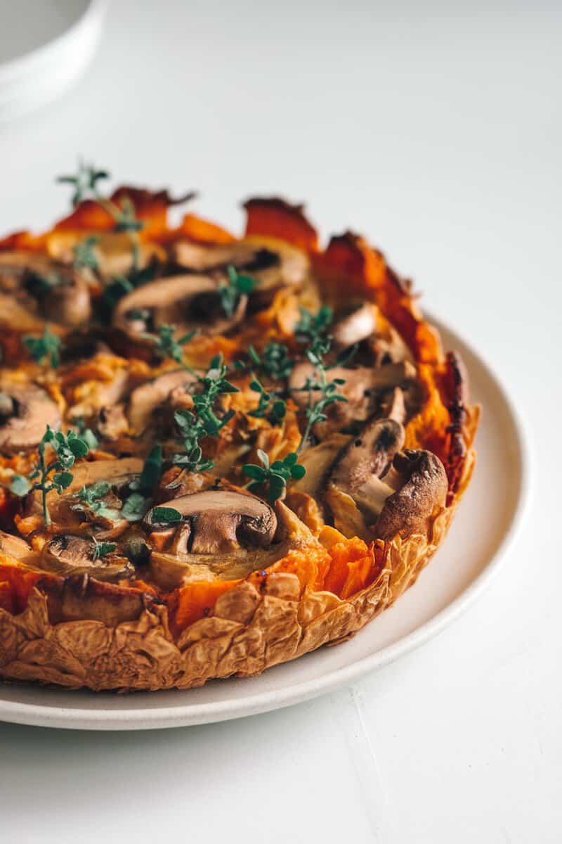 A delicious Mushroom and Sweet Potato Bake topped with fresh herbs.