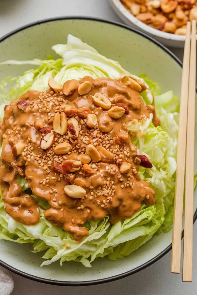 Napa cabbage slaw topped with peanut dressing, crushed peanuts, and sesame seeds.