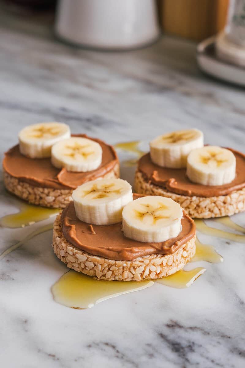 Nut butter and banana rice cakes topped with honey on a plate