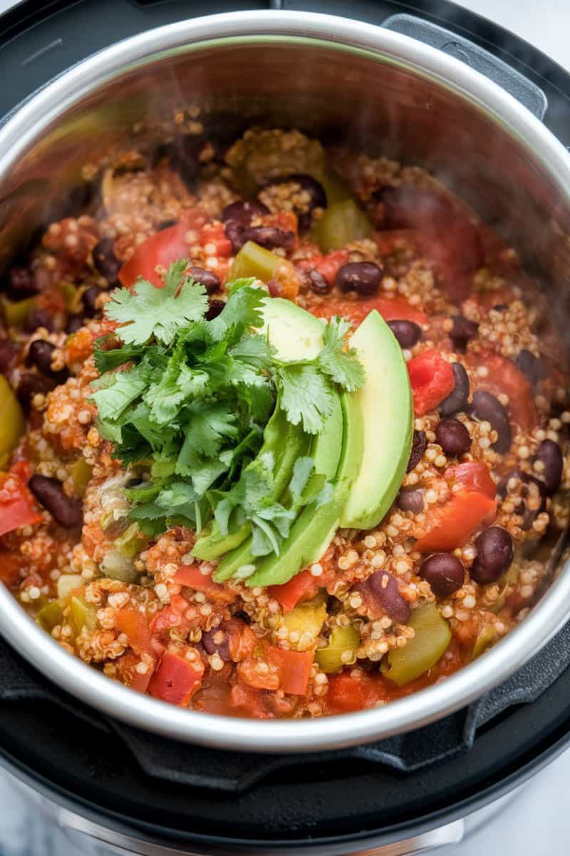 A delicious bowl of quinoa and black bean chili topped with avocado and cilantro.