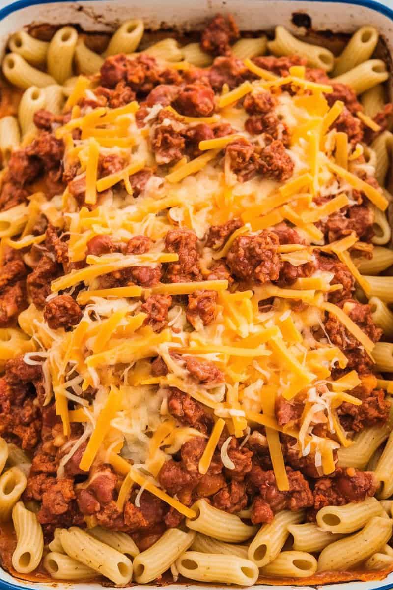 A close-up of a Taco Meat Pasta Bake topped with melted cheese and taco meat over pasta.