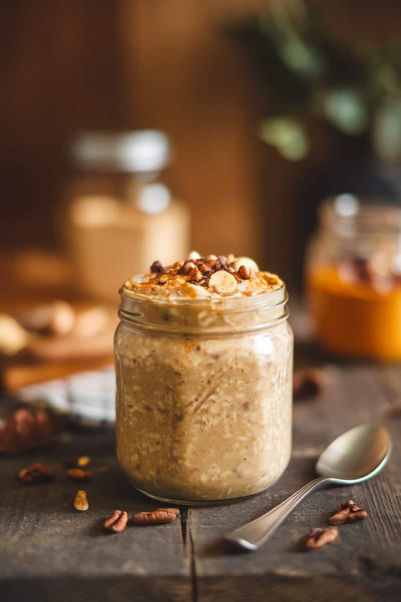 A jar of creamy pumpkin spice overnight oats topped with nuts.